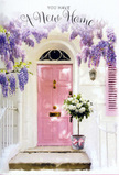 The scene shows a charming Mayfair doorway turned into a quiet celebration of a new chapter, where every element seems chosen to whisper welcome. A smooth, pastel pink front door stands at the centre, its colour soft and calming, like the inside of a shell. One shutter, brushed in the same gentle blush, sits slightly open against a whitewashed wall, whose faint, uneven texture adds character and hints at an older building. Overhead, cascades of wisteria fall in dreamy trails of lavender and lilac, their blossoms clustered along slender stems that drape over the lintel and down the sides of the entrance. The trailing flowers catch the soft daylight, casting dappled, shifting shadows that play across the door and step, reminiscent of a leafy corner near Green Park in late spring. On the doorstep itself rests a vintage-style grey bucket, its subtle scuffs giving it a lived-in charm. From this container spills a lush, hand-crafted arrangement of white and cream roses, their layered petals opening in spirals, brushed by touches of fresh green foliage that soften the edges. A delicate pink ribbon is tied around the bucket, its ends trailing casually, bringing a note of romance and care. The whole composition feels like a moment captured just before someone arrives home for the first time: flowers delivered, door waiting to be opened, and the calm air filled with a mix of floral sweetness and quiet hope, making it a perfect visual metaphor for housewarming wishes and new beginnings in this elegant corner of London.